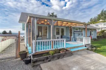 There is a large, covered deck on the back of the house. Translucent plastic allows sunlight in. The covered deck is like an extra room. This deck looks out to a green space, and over the neighbor's yard- which cannot be developed.