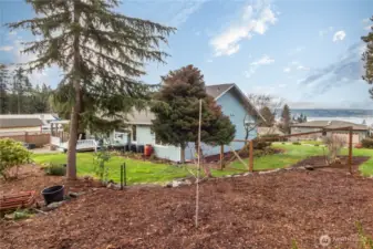 Upper back yard area is covered with mulch for easy maintenance.