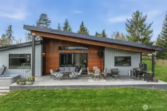 Covered back patio brings indoor living outside~so nicely done!  There is a TV there too!