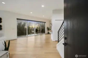 Expansive sliding glass doors connect living space to deck and backyard