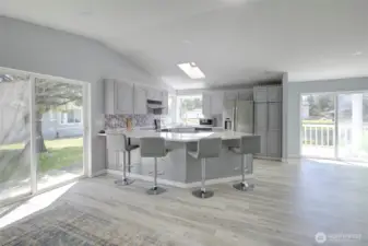 Light-filled, updated kitchen with modern finishes, generous counter space, ample cabinets, stainless steel appliances, and a a cheerful backsplash - perfect for everyday living and easy entertaining.