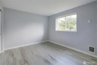 Bedroom One - Comfortable and bright downstairs bedroom, perfect for guests, a home office, or a cozy retreat. Features a large window that fills the space with natural light and a convenient layout that blends seamlessly with the main living areas