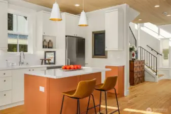 The luxurious cooks kitchen features a large, deep Kohler sink, quartz countertops and warm color accents.