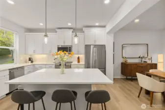 a sleek kitchen w/quartz counters, glass tile backsplashes, & top-ranked SS appliances.