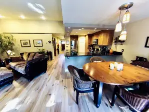 Inviting open-concept living, dining, and kitchen area that’s ideal for both entertaining and everyday living. The space features beautifully maintained hardwood floors, vaulted ceilings with recessed lighting, and a warm, neutral color palette that creates a welcoming ambiance.