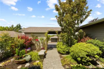 A beautifully landscaped walkway leads directly from the carport to the home’s welcoming front entrance.