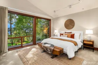 Tranquil, private, and light-filled, the main-floor primary suite features filtered lake views and a blooming dogwood that brings seasonal beauty each spring.
