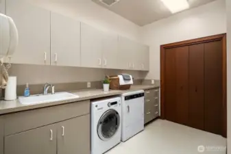 The generous laundry room features a utility sink, abundant storage, and ample space for sorting, folding, and organizing.