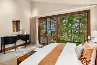 With vaulted ceilings, oversized windows, and serene lake views, the main-floor primary bedroom feels both spacious and retreat-like.