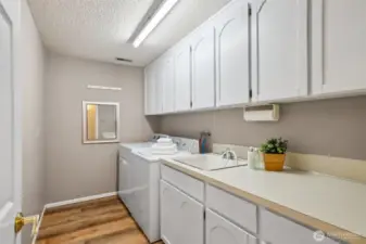 Large & practical laundry room! Loads of cabinets + sink!