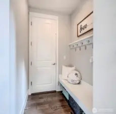 Mudroom with built-in bench and garage access