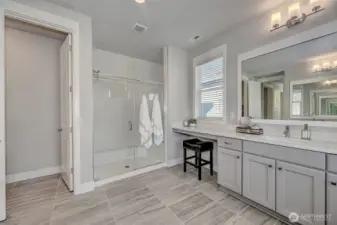 5-piece primary ensuite with an extra long countertop with sitting area