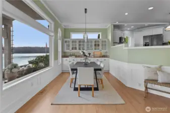 Light-filled dining area with built-in cabinetry and expansive windows showcasing beautiful waterfront views.