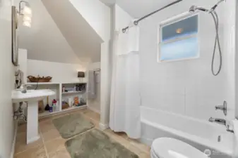The full bath is large and has ceramic tile floors and a pedestal sink.
