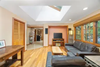 The family room is beyond the kitchen and has a large pantry/closet to the left. This room also looks out toward the driveway and the large trees beyond.