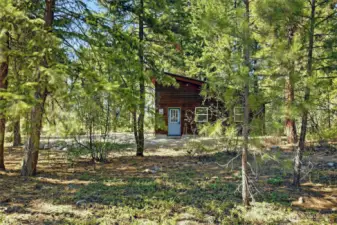 The garage is tucked within a lovely forested setting with plenty of room for a future home.