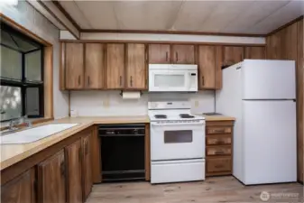 Functional kitchen with ample cabinet storage and efficient layout, offering plenty of workspace for everyday cooking. Natural light from the window enhances the space while providing a comfortable and practical design.