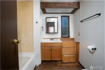 Comfortable bedroom featuring natural light and a spacious closet with built-in shelving for added storage. Functional layout provides flexibility for everyday living or guest use.    Bathroom featuring a functional layout with vanity storage and a tub/shower combination. Warm finishes create a comfortable and practical space for everyday use.