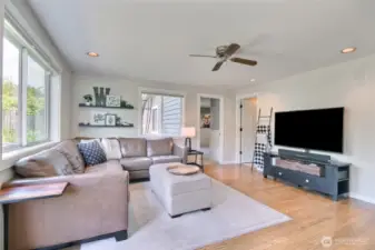 Recessed lighting and warm-toned hardwood floors add to the family room's welcoming ambiance.