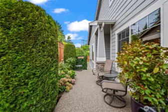 The lush pathway of the side patio leads to the entrance of the home.