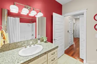 Guest bathroom on main level has a surround shower and bathtub.