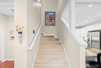 An inviting staircase to the 2nd level has two decorative wall sconse light fixtures.