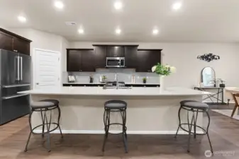The massive quartz island centers the kitchen.