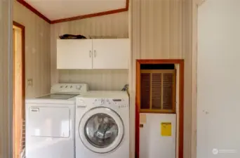 The utility room off the kitchen near the rear entry to the home that leads to the backyard where the entry to the finished bonus room is located.