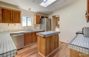 The kitchen with an island has the utility room nearby.