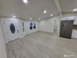 Heading toward the doorway next to the fridge, into room #1 (that has full bath directly off)