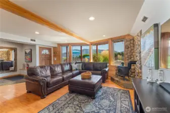 View 1 of lower level living/media room w/ fireplace, dining area and 2nd kitchen w/ doors leading out to the patio w/ pool, hot tub, basketball court and dining and lounge area.