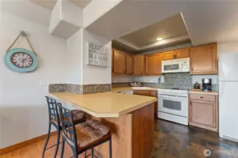 View 3 of lower level living/media room w/ fireplace, dining area and 2nd kitchen w/ doors leading out to the patio w/ pool, hot tub, basketball court and dining and lounge area.
