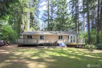 Back of house with full length deck and fire pit area.
