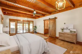 Huge Master Bedroom with Barn Doors, Hardwood Flooring and Wood Plank Ceiling