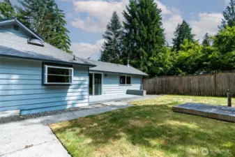 Back yard features both a deck for relaxing, and extra concrete patio space for entertaining