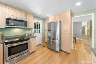 A thoughtful layout connects the kitchen to the main hallway and dining room, offering a seamless flow for cooking, entertaining, and everyday gathering. Beautiful crown molding and cabinetry adds an elegant touch to this inviting space.