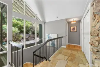 Just off the entry, this sunlit hallway offers additional closet storage and leads to the powder room and the tranquil Primary Suite.