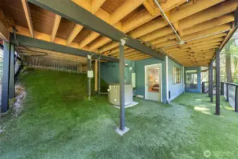 A fully fenced lower-level area with turf, ideal for a dog run or private outdoor space with covered protection year-round enjoyment.