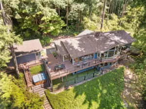 A stunning perspective showcasing this expansive 1-story with basement home—complete with an entertainer’s dream deck, a serene hot tub retreat, and ultimate privacy surrounded by lush Bridle Trails forest.