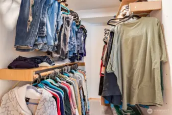 Walk-in closet with built-in shelving and rods keeps everything neat and organized.