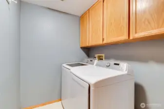 Dedicated laundry room with upper cabinetry for storage and space to fold or organize. Washer & dryer included in the sale!