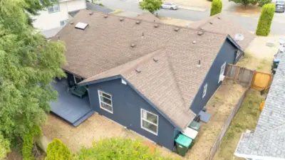 Aerial view shows the home’s full footprint, backyard deck, and low-maintenance landscaping.