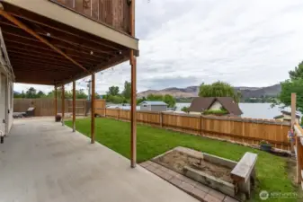 Lower yard area with horseshoe pit, slider to the left that goes directly into living and kitchen area on the 2nd level