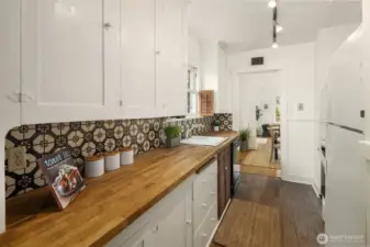 Kitchen with butcher block counter, solid wood cabinetry and fun tilework.