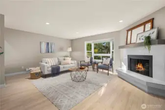 Bright and large living room with wood burning fireplace.