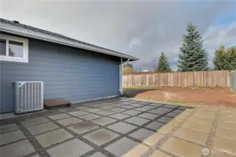 Backyard patio area with paver-style walkway, ideal for outdoor seating or entertaining.