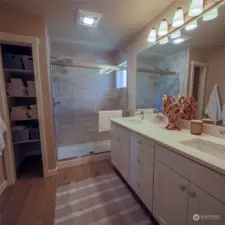 primary bathroom with quartz countertops and beautiful tile walk-in shower.