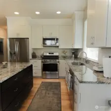 Beautiful kitchen with granite counter tops & newer, tall cabinets with stainless steel appliances.