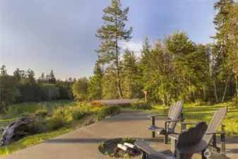Peaceful outdoor patio with firepit and seating, surrounded by natural beauty and serene forest views.