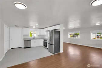 Entryway view showcasing the kitchen at the front and large living room nearby.